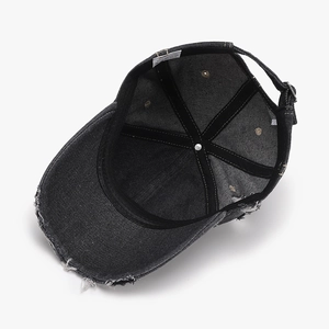 Inside view of distressed black denim baseball cap showing 100% cotton label
