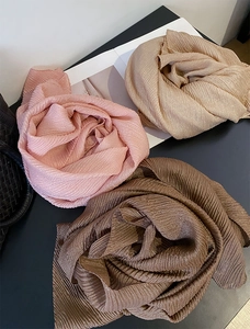 Dettaglio di eleganti sciarpe a pieghe a forma di rosa con una sottile texture luccicante