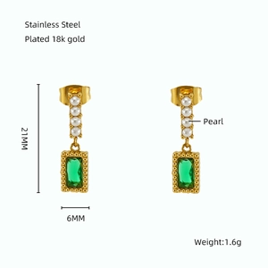Detail of vintage 18k gold plated stainless steel earring with pearl and green stone