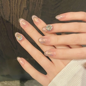 Close-up of pink cat eye press-on nails with sparkling rhinestones and glitter finish
