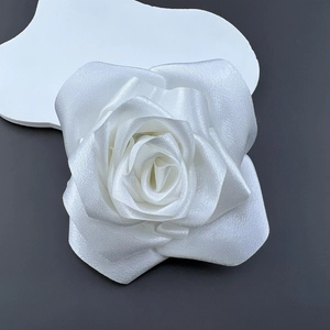 Macro shot of 11cm white fabric camellia rose with elegant satin texture and petals