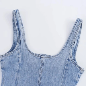 Dettaglio dello scollo e delle spalline dell'abito in denim azzurro con cuciture rifinite