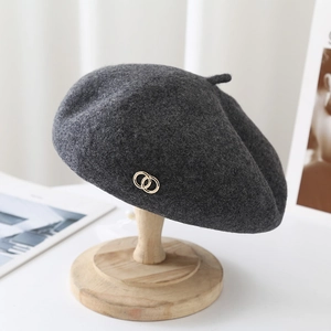 Close-up of dark grey wool beret featuring a stylish golden double ring metal buckle