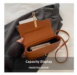 Detail view of the brown saddle bag interior showing space for a smartphone and metal buckle