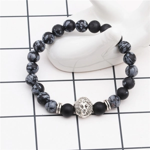 Detailed shot of beaded lion head bracelet with black matte beads and natural stone on a hand model