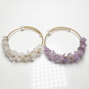Detail of 14K gold wire-wrapped bracelets with amethyst and clear quartz crystals