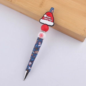 Detail of Christmas beaded pen featuring blue barrel, Santa hat bead, and red snowflakes
