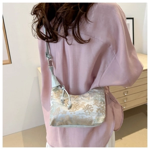 Detailed back view of a light blue jacquard crossbody bag with elegant gold patterns