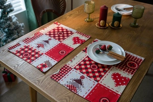 Close-up of Christmas plaid placemats with festive patchwork on a dark wooden dining table