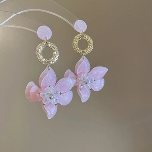 Detailaufnahme der rosa Harzblumenohrringe mit Goldreif und Kristallperlen
