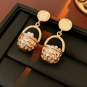 Detail of vintage gold flower basket earrings with pearls in a black jewelry box