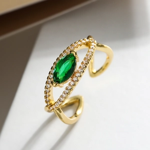 Macro detail of gold plated ring with marquise green zircon and side stone accents