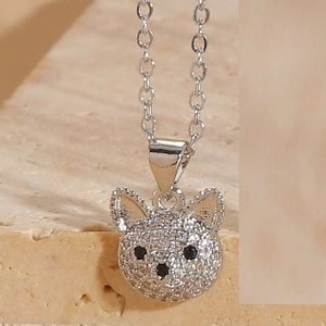 Close-up of cute dog pendant with pavé cubic zirconia and black gemstone accents