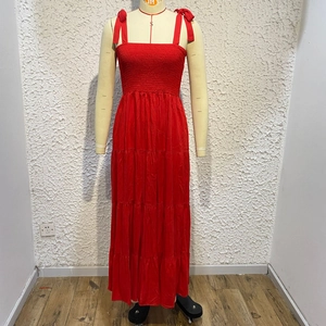 Detail of red summer maxi dress featuring adjustable tie straps and a tiered cake skirt