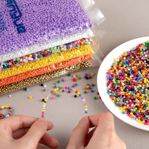 Close-up of hands threading colorful DIY beads for handmade jewelry making
