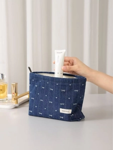 Vintage denim makeup bag with white bow prints and zipper closure in deep blue canvas