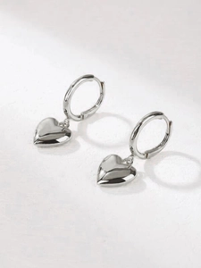 Detailed view of silver polished heart-shaped pendant earrings with elegant hoop closure