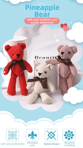 Detail of three knitted teddy bear pendants in red, white and pink with pineapple texture