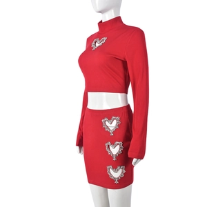 Detail of red ribbed knit set with rhinestone heart cutout and long sleeve crop top