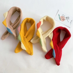 Detail of four colorful knitted baby scarves in brown, yellow, beige and red with patterns