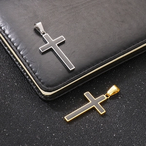 Detail view of gold and silver stainless steel cross pendants on a dark background