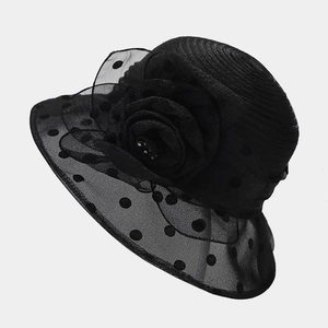Detail of elegant black sun hat with large organza flower and polka dot mesh brim