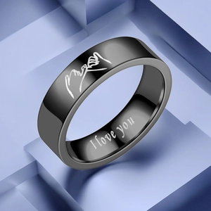 Detail of black titanium couple ring featuring hand-holding pattern and I Love You engraving