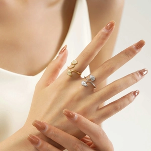 Close-up of gold and silver stainless steel leaf rings worn on a model's hand