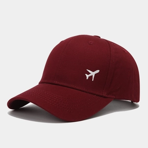 Gros plan sur la broderie d'avion blanc d'une casquette de baseball bordeaux en coton