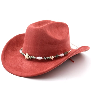 Detailed close-up of red suede cowboy hat with bohemian style beaded star band accessory