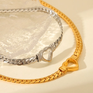 Close-up of hollow heart pendants on gold and silver curb chain necklaces with ice texture