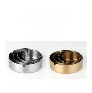 Detail view of gold and silver brushed stainless steel ashtrays with U-shaped slots