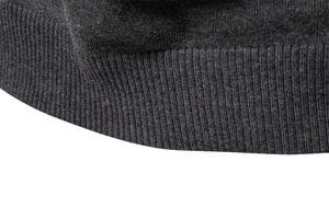 Vue détaillée de l'ourlet à bord-côte extensible sur ce pull en maille gris foncé cintré