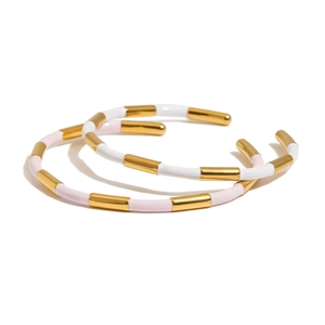 Bamboo style open bangles in gold and pink enamel finish on a white background
