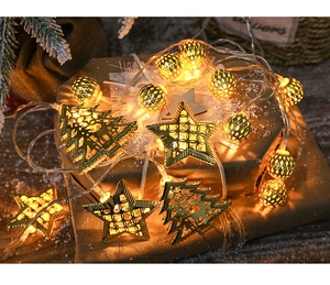 Detail of warm LED Christmas string lights on a gift box with hollow metal stars and spheres