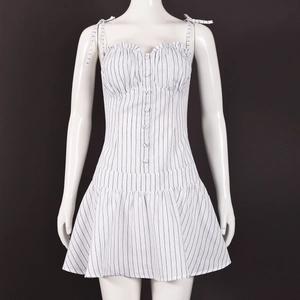 Detail view of white striped dress featuring ruffled neckline and button decorations