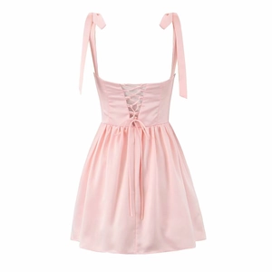 Detailed back view of pink satin dress showing criss-cross lace-up design and straps