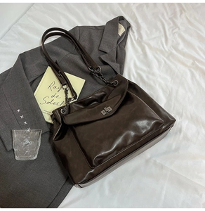 Dettaglio borsa tote vintage in pelle PU marrone con chiusura a rotazione e catena