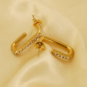Gold plated titanium steel U-shaped earrings with sparkling cubic zirconia on satin fabric