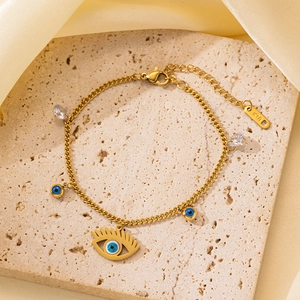 Detalle de pulsera de ojo turco dorada con dijes azules y sello K18 en la cadena ajustable