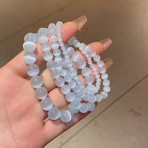 Close-up of elegant light blue cat-eye beaded bracelets in various bead sizes