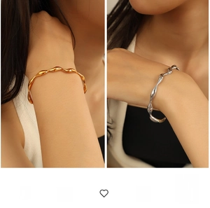 Macro detail of geometric wave open bangle in polished gold and silver finishes