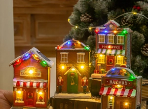 Miniature Christmas resin houses with LED lights showing candy shop and bakery details