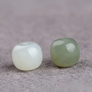 Macro detail of polished Hetian jade beads in white and light green for DIY jewelry