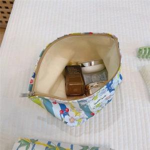 Detail of floral and striped makeup bag showing large capacity for skincare items
