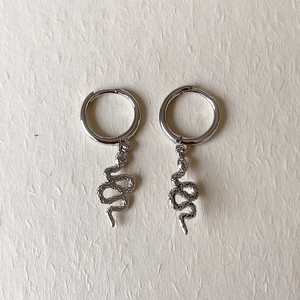 Detailed macro view of S925 sterling silver snake pendant earrings with polished finish
