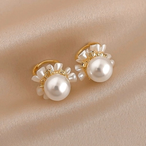 Elegant gold pearl flower earrings displayed on luxury champagne silk fabric