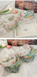 Detail of floral embroidery on wide mesh headband with delicate pastel flower patterns