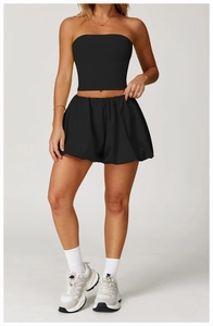 Detail view of high-waisted black quick-dry sports shorts and slim tube top on a model