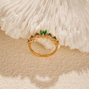 Detailed close-up of adjustable gold heart ring with green zircon and retro luxury style
